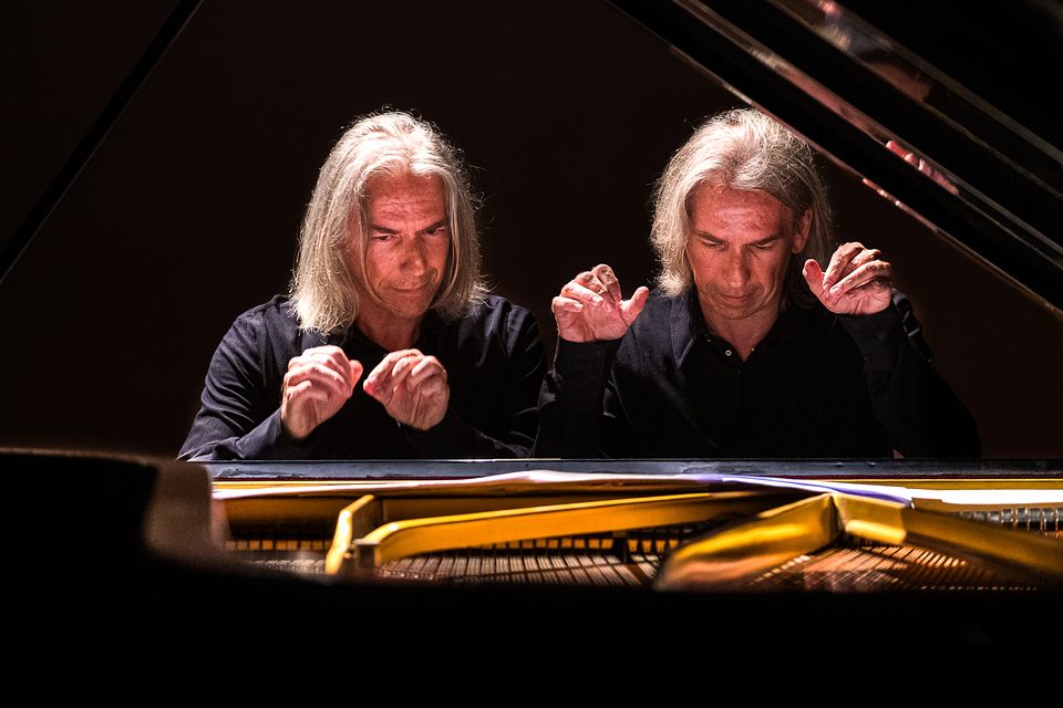 Davide e Daniele Trivella al pianoforte, le mani sollevate sopra la tastiera